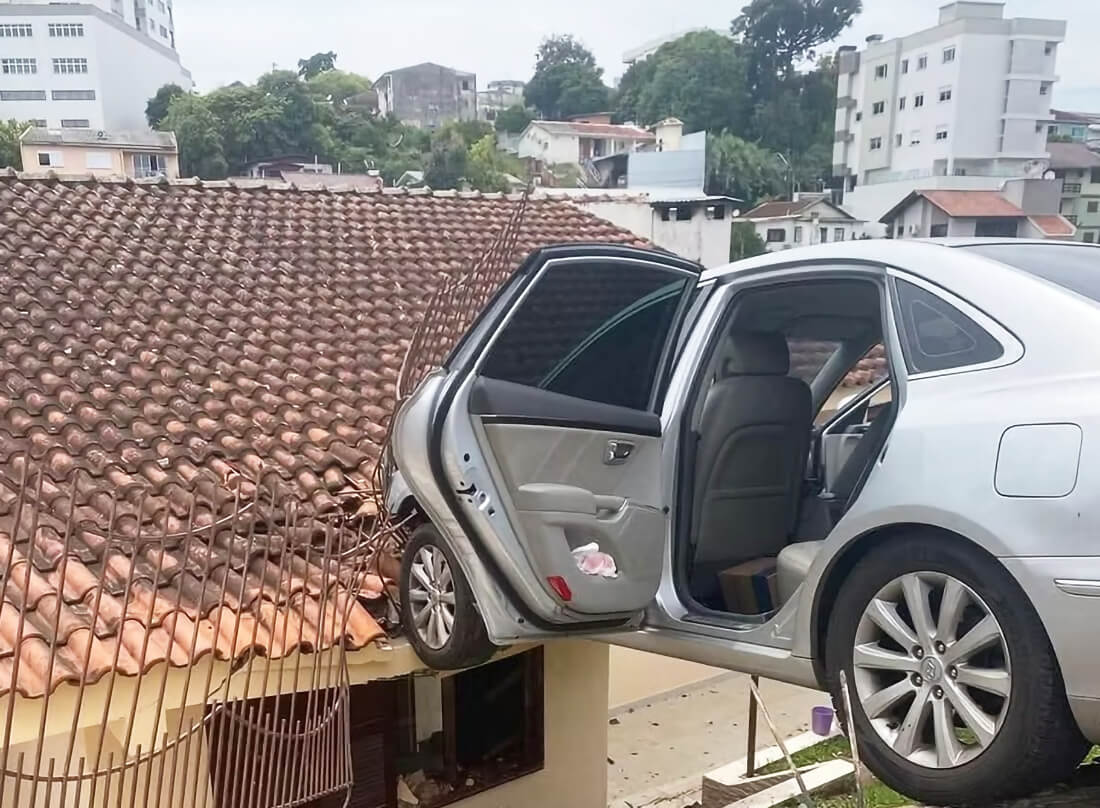 Capa Carro automático desgovernado com criança a bordo colide em cerca e fica suspenso
